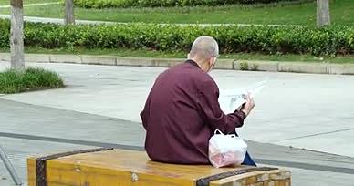 4K老人看报纸户外公园老人背影看报纸怀旧视频的预览图